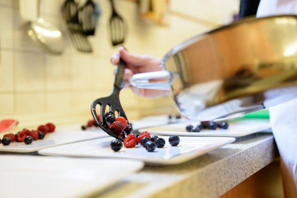 Ein Teller wird mit Obst befüllt Ein Teller wird mit Obst befüllt