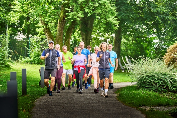 Outddoor Walking-Gruppe auf dem Weg durch den Park Outddoor Walking-Gruppe auf dem Weg durch den Park